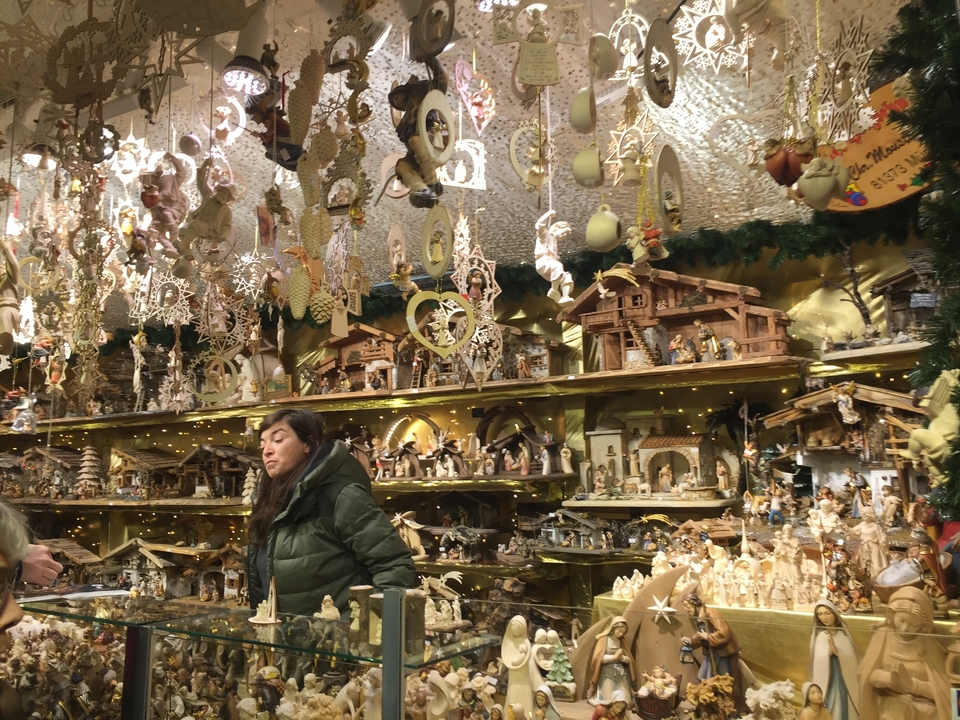 Une femme qui parcourt un étal de marché rempli d'articles de Noël faits à la main.