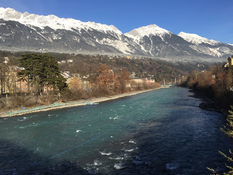 Une rivière tranquille avec un arrière-plan de montagnes enneigées.