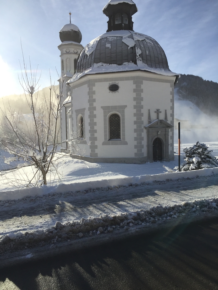 Une petite église entourée de neige par une journée d'hiver ensoleillée.
