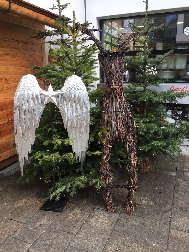 Décorations extérieures sur le thème de Noël, incluant des ailes d'ange et des guirlandes lumineuses.