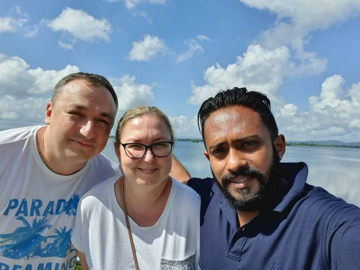 Three people posing together outdoors.