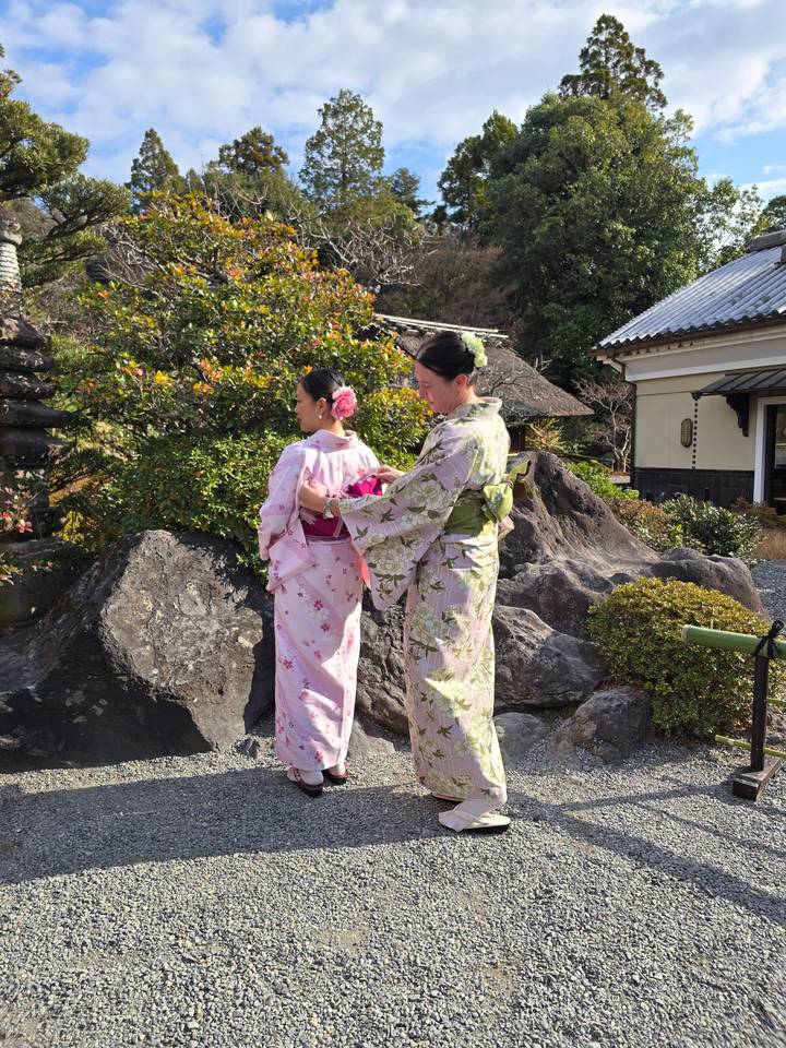 Deux personnes en vêtements traditionnels posant à l'extérieur.