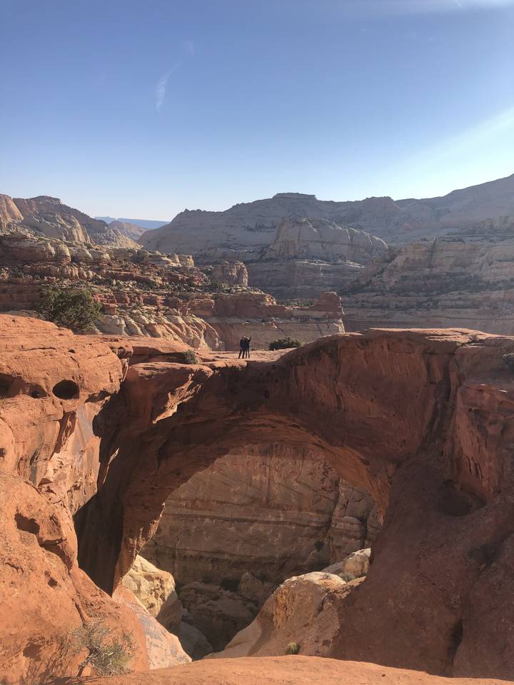 Grande arche de roche avec un vaste paysage derrière.
