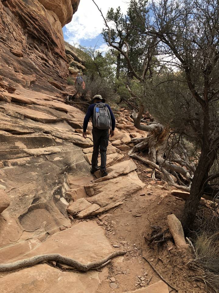 Une personne qui fait de la randonnée sur une pente rocheuse.