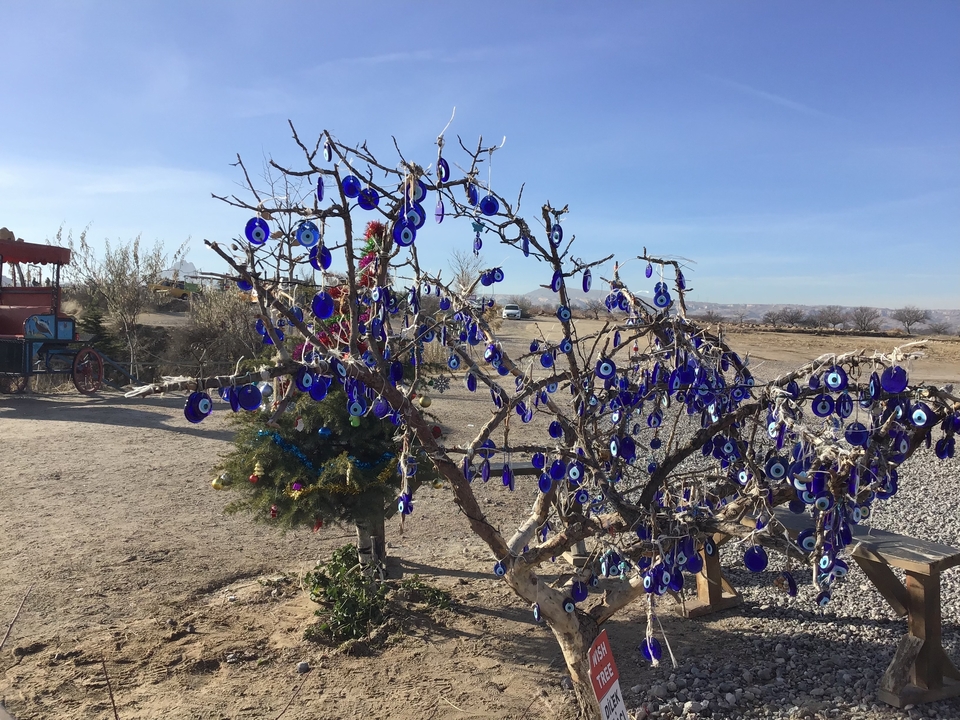 Un arbre décoré d'ornements bleus dans un décor désertique.