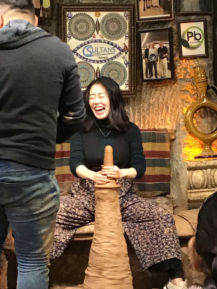 Femme façonnant de la poterie en riant.