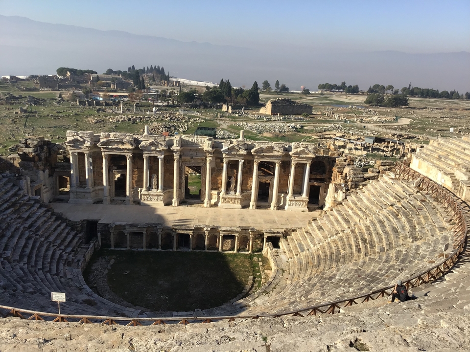 Ruines antiques avec un grand amphithéâtre au premier plan.