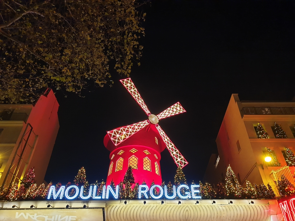 Moulin Rouge la nuit avec des lumières illuminant le moulin à vent rouge