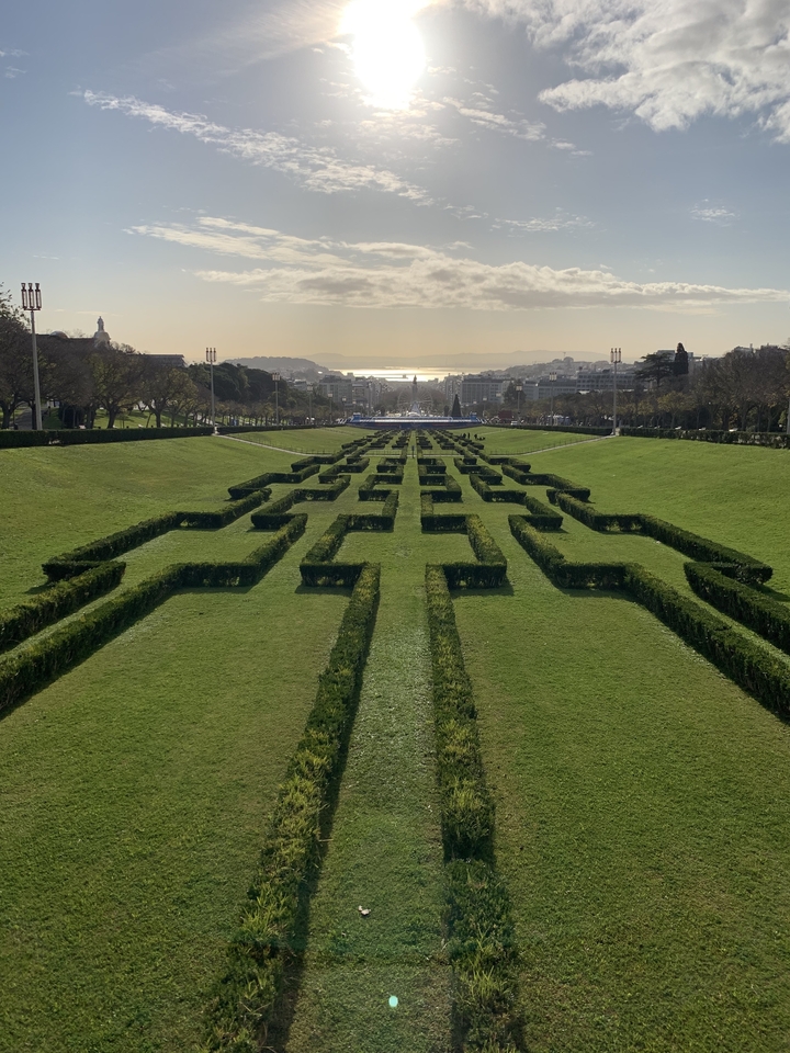 Parc aux haies géométriques menant vers l'horizon urbain