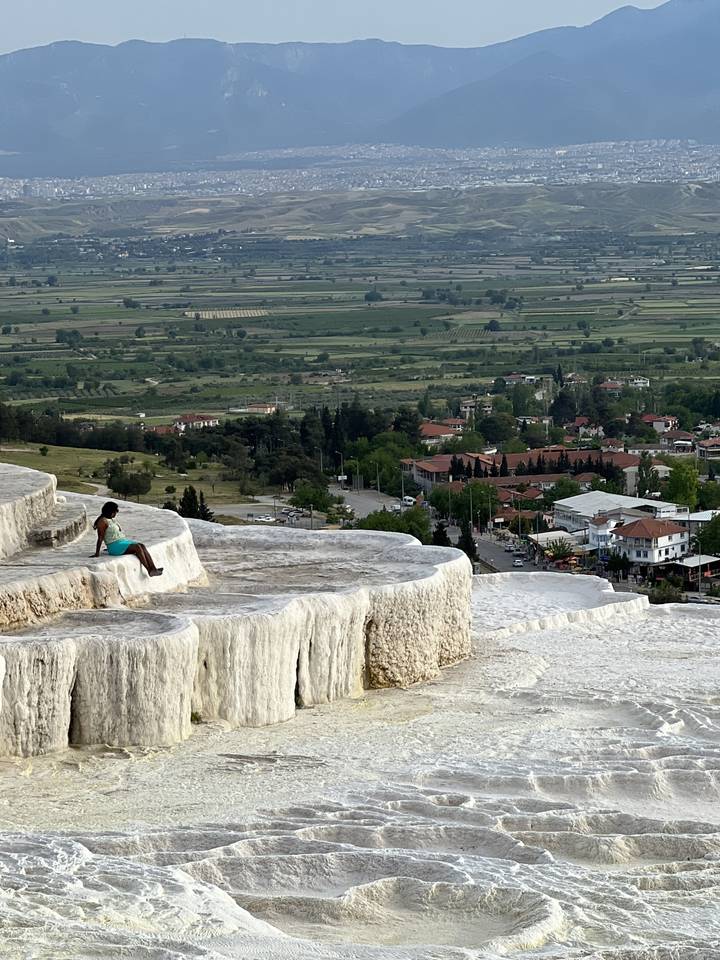 Paysage en terrasses avec voyageurs et formations blanches.