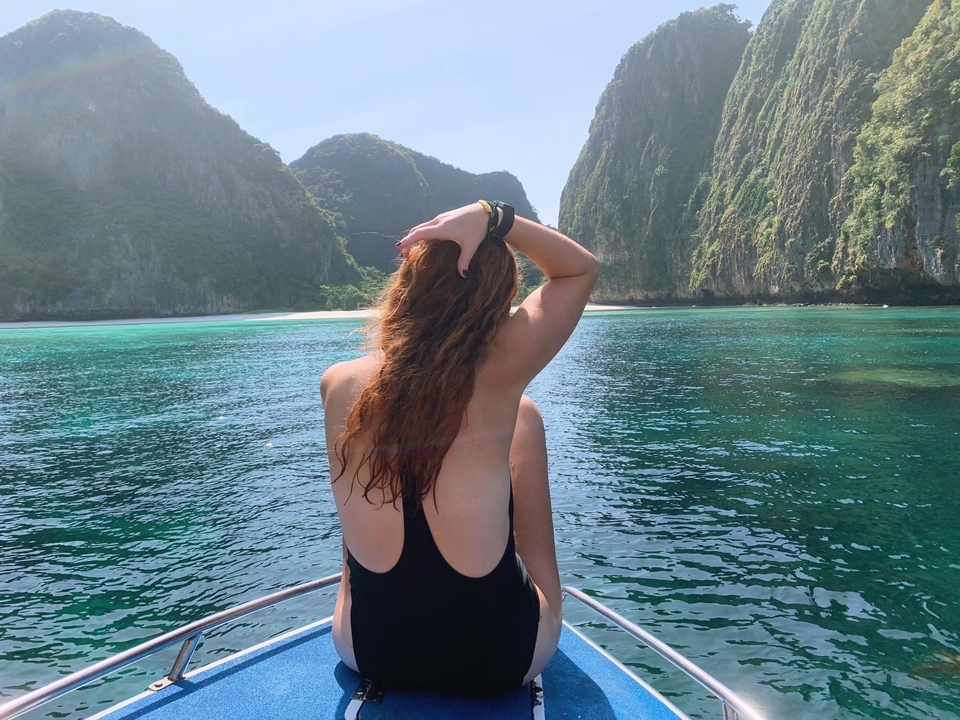 A person enjoying a boat ride amidst stunning cliffs.