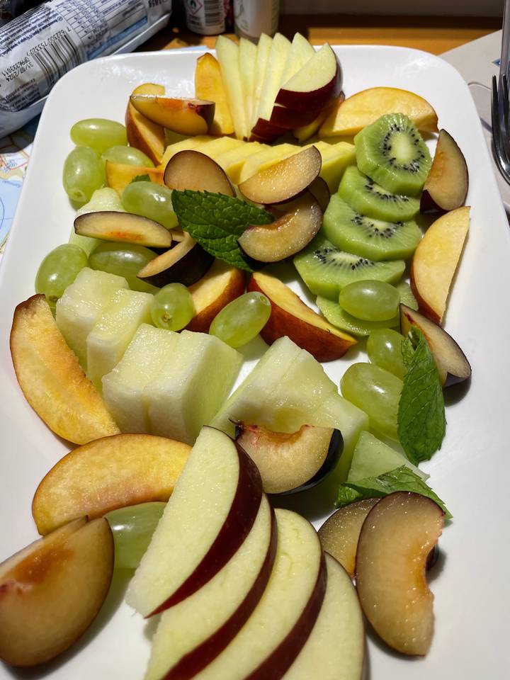 Assortiment de fruits tranchés soigneusement disposés sur une assiette.