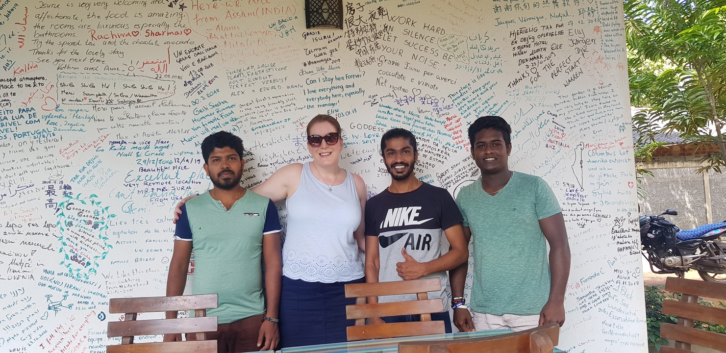 Groupe de personnes posant devant un mur avec des écritures.