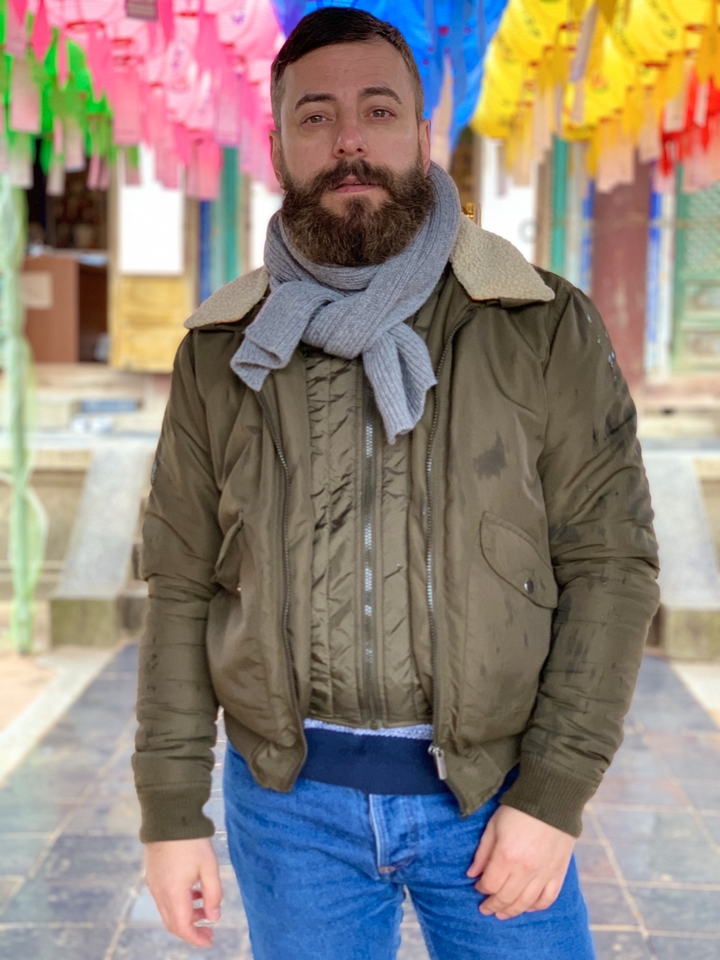 Une personne en vêtements d'hiver debout avec un bâtiment historique en arrière-plan.