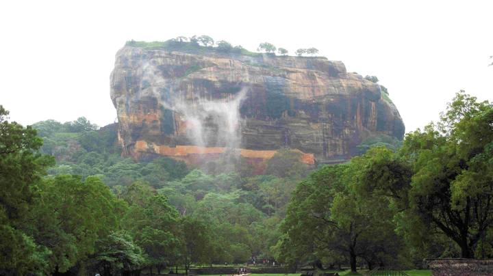 Forteresse rocheuse de Sigiriya s'élevant au-dessus des arbres.