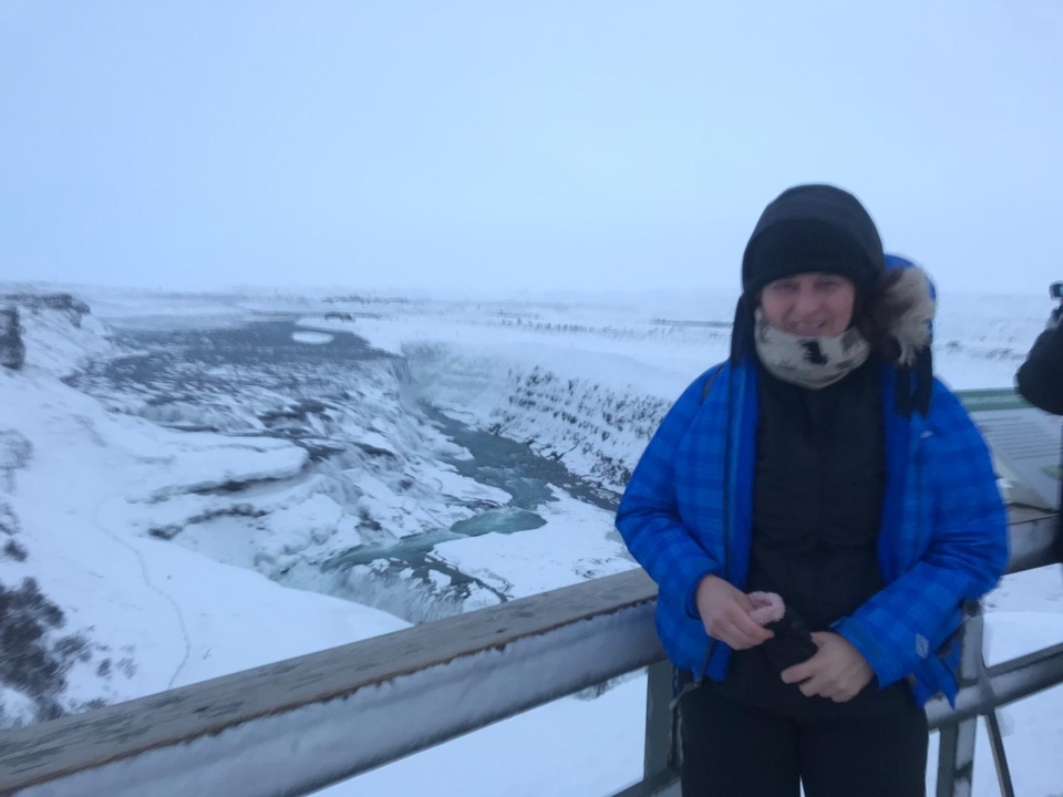 Individu debout sur une plateforme enneigée surplombant un canyon