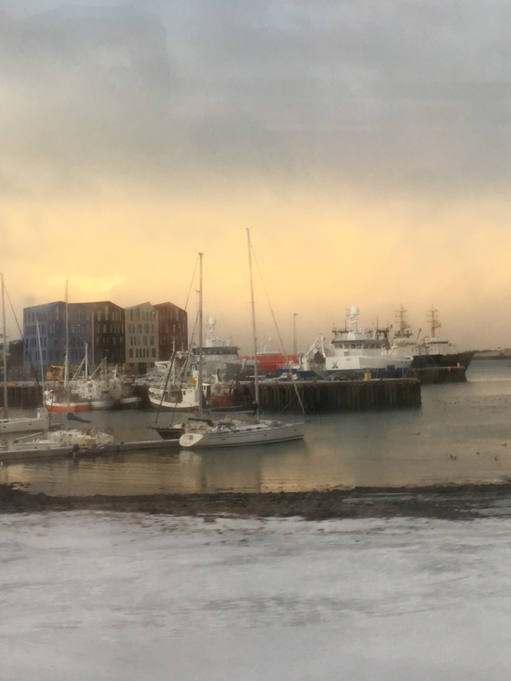 Image floue de navires amarrés dans un port avec des bâtiments industriels