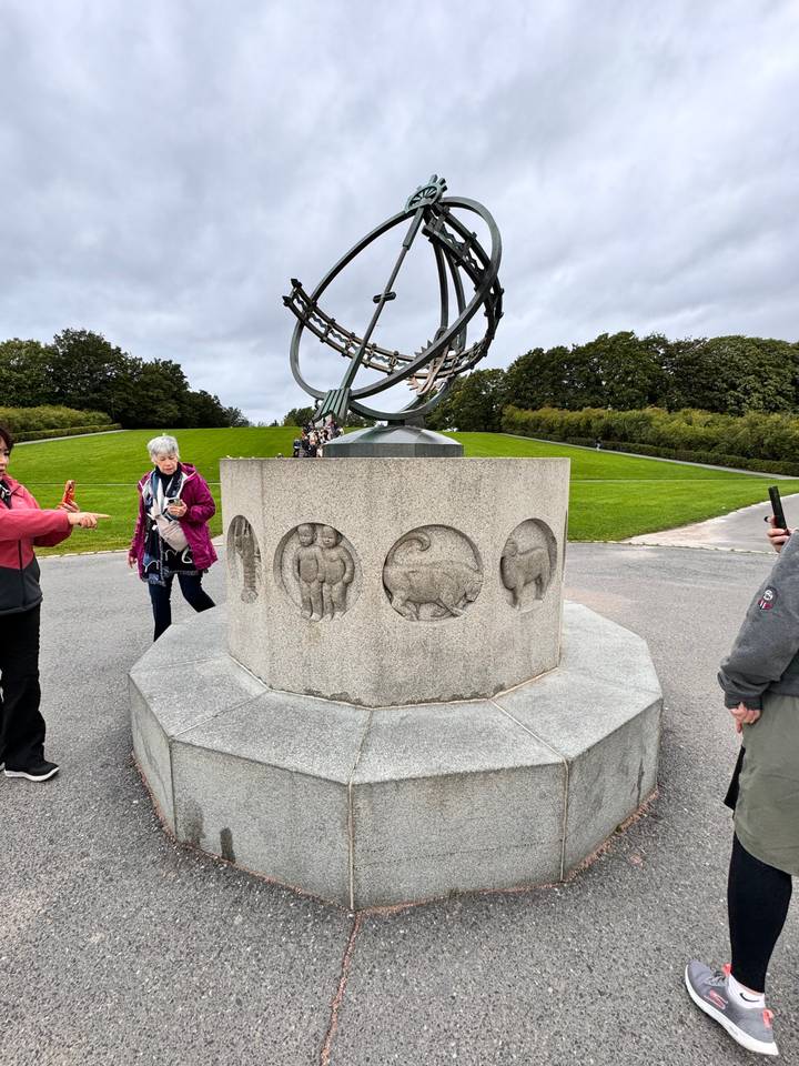 Un monument en pierre avec des motifs célestes et une personne à proximité.