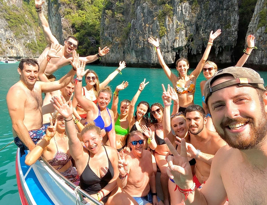 Groupe sur un bateau avec une eau turquoise magnifique et des falaises.