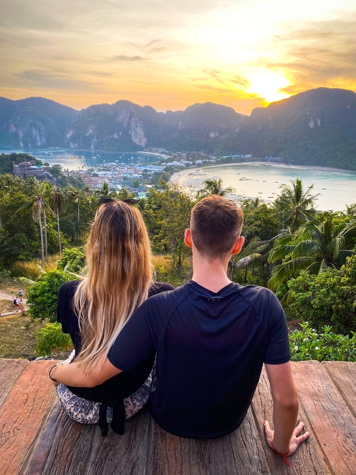 Couple overlooking a lush green landscape with bay views.