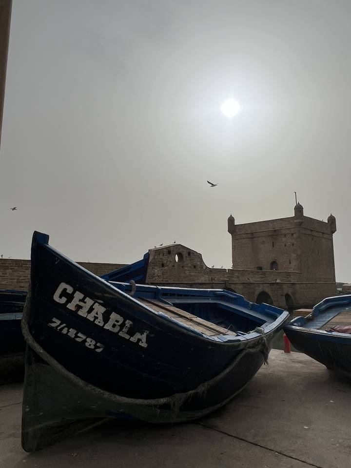Bateau et bâtiments en pierre sous un soleil éclatant.
