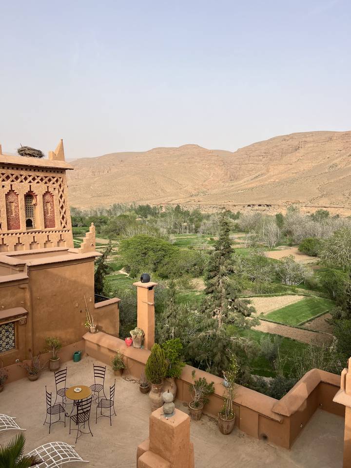 Terrasse avec vue sur les collines du désert et la verdure.