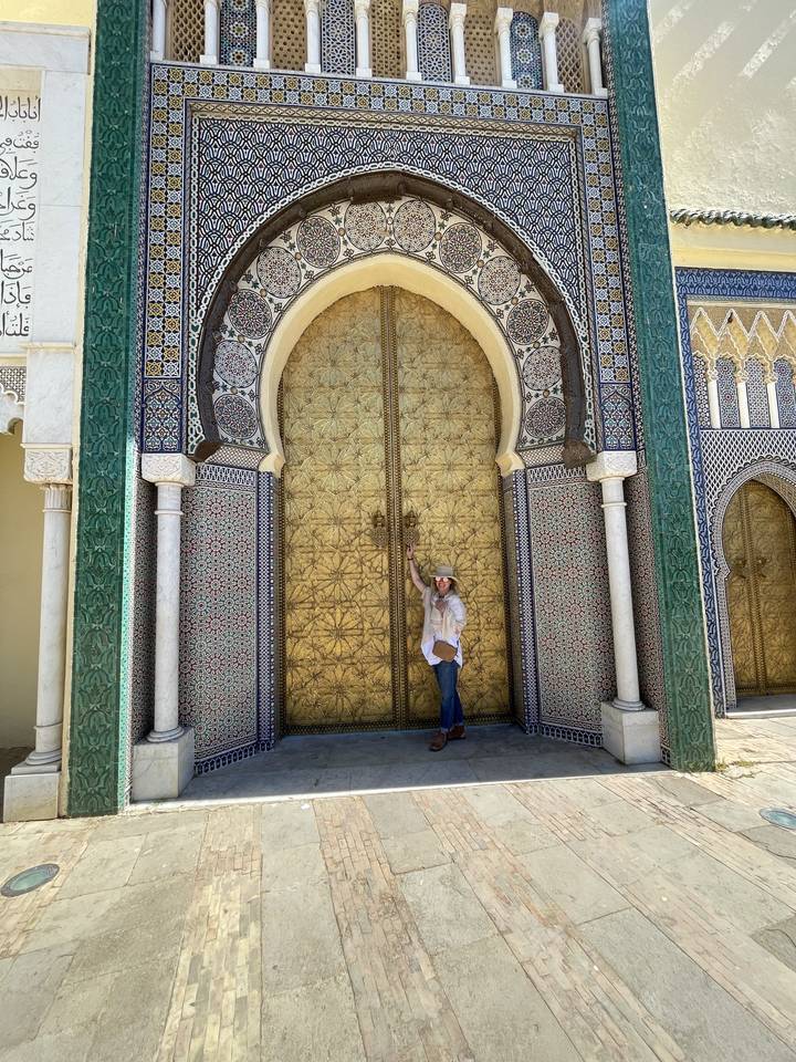 Personne debout à côté d'une porte ornée.