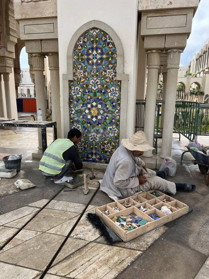 Artisans travaillant sur un art de mosaïque détaillé.