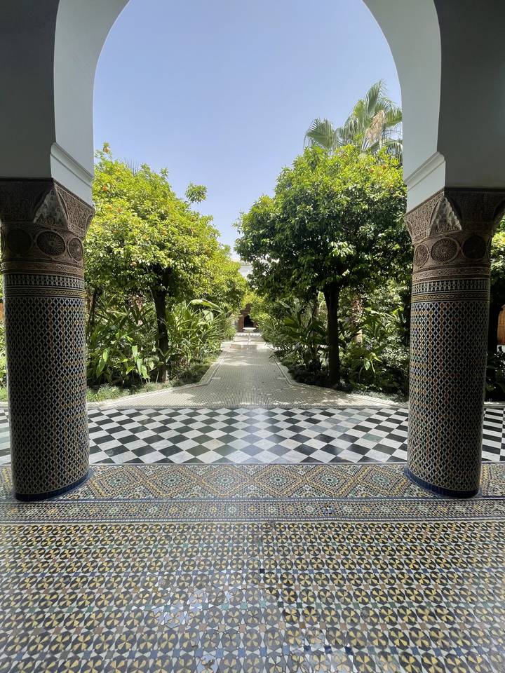 Arcade magnifiquement carrelée avec vue sur un jardin luxuriant.