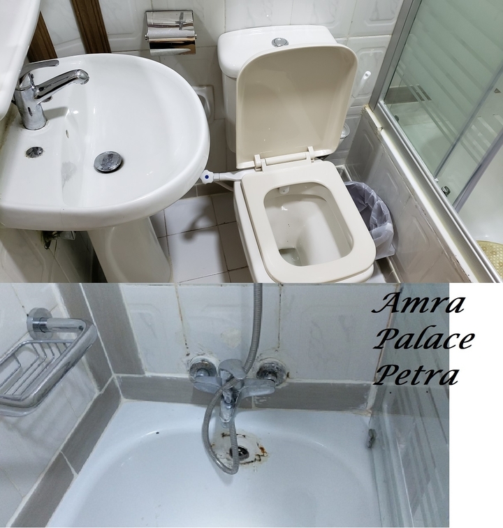 Salle de bain avec toilettes et lavabo, et nom de l'hôtel.