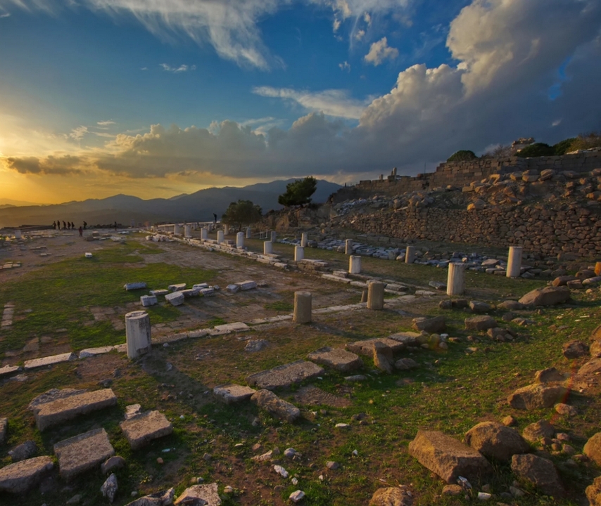 Ruines au coucher du soleil avec un arrière-plan vallonné.