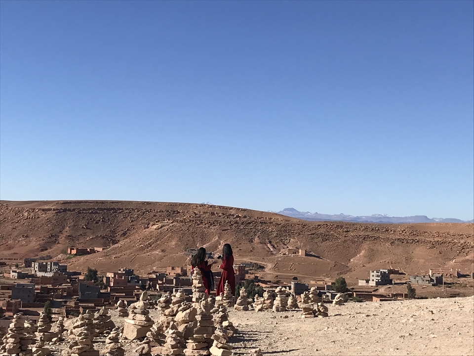 Vue sur un village marocain avec des montagnes au loin.