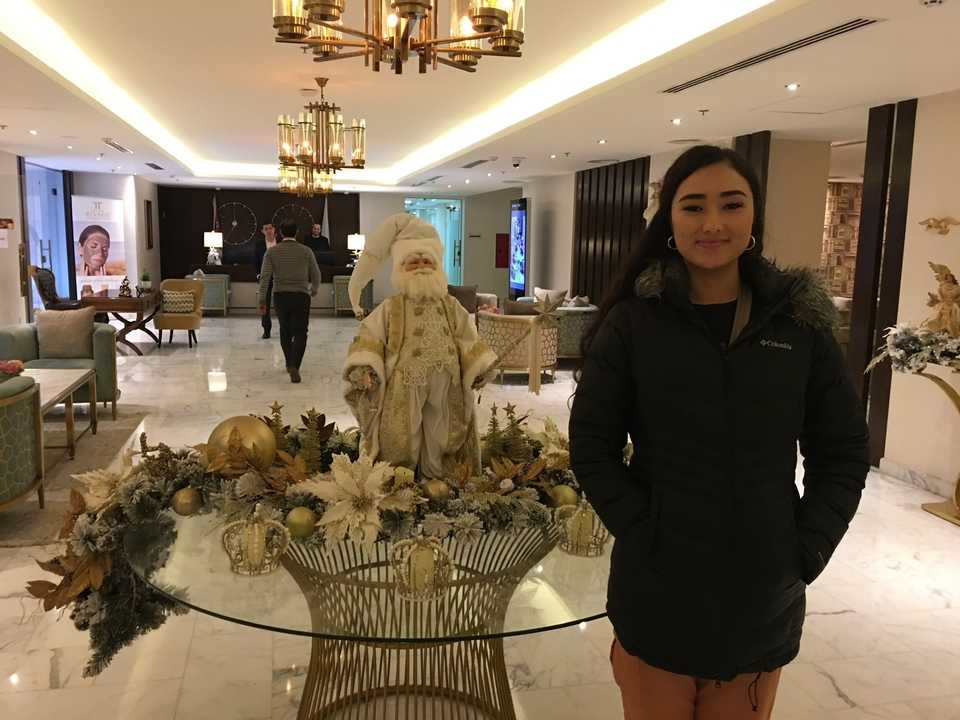 Lobby d'hôtel décoré pour les fêtes avec statue et décorations.