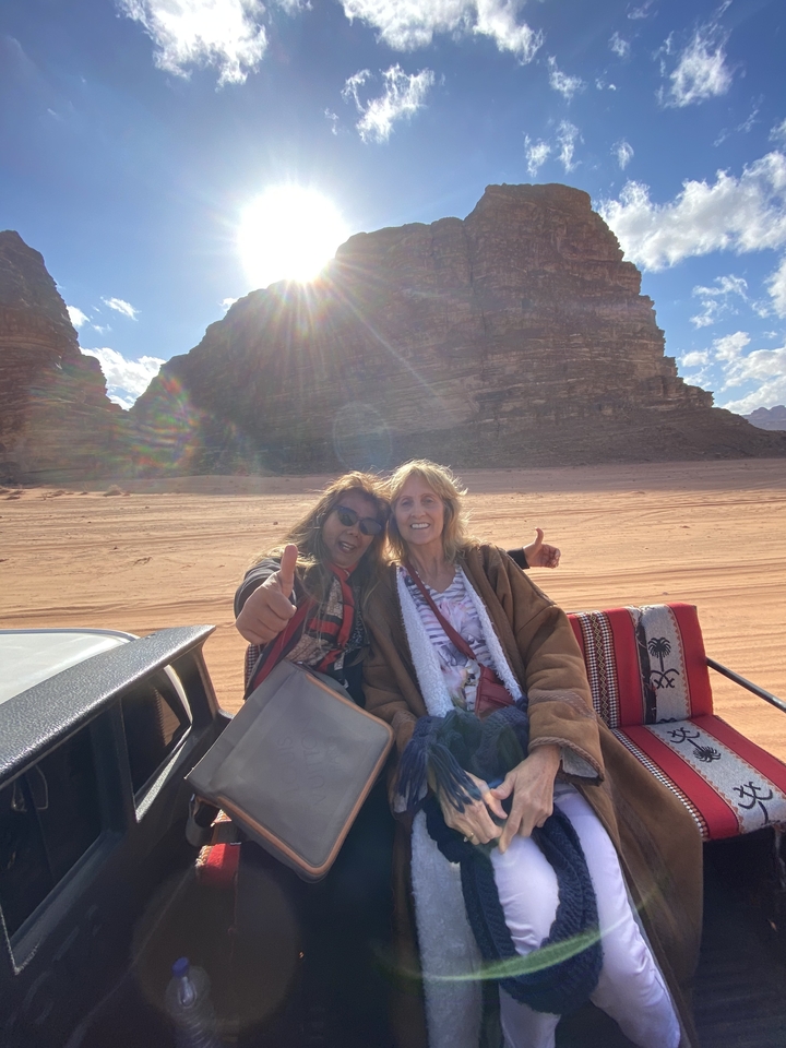 Deux femmes lors d'une balade en jeep dans un paysage désertique.