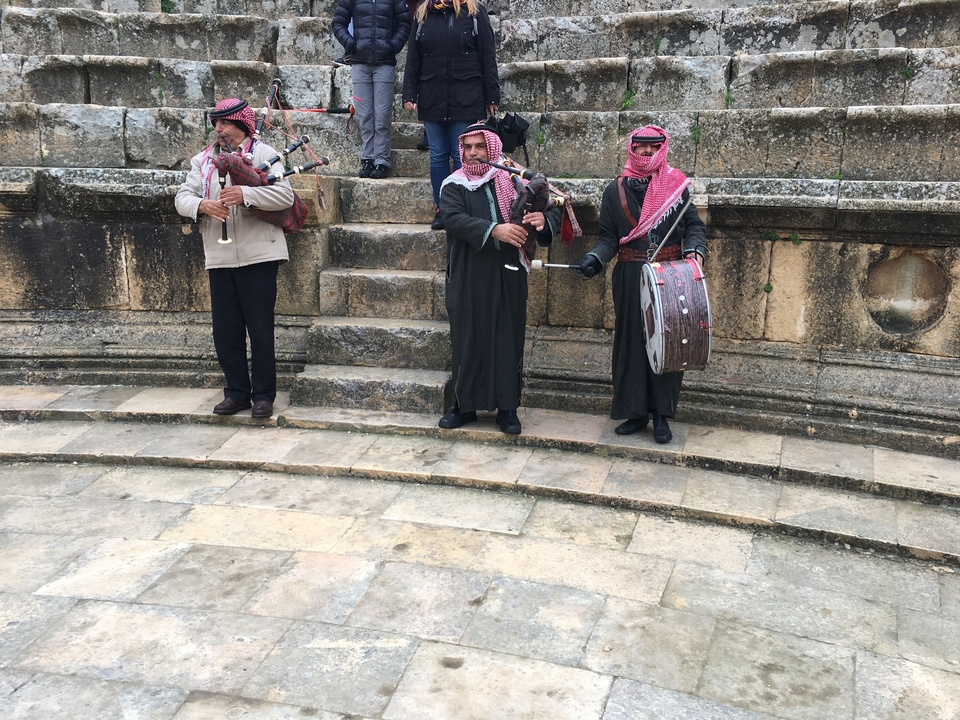 Musiciens portant des vêtements traditionnels sur un site patrimonial.