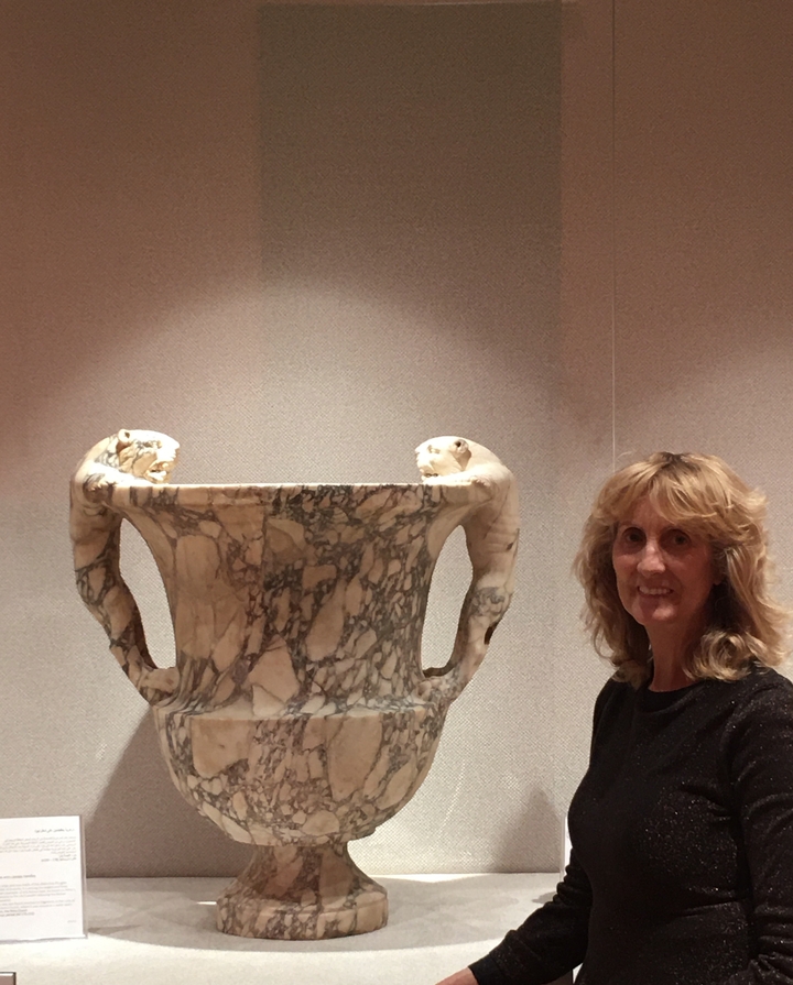 Personne posant à côté d'un artefact de musée.