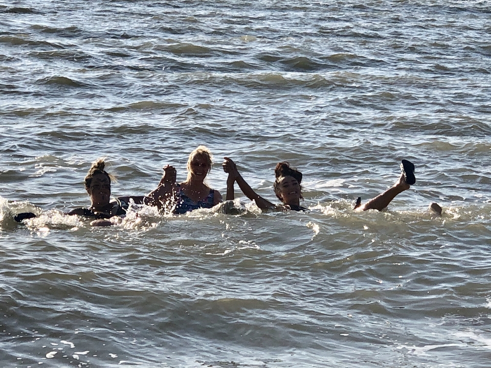 Trois personnes flottant dans l'eau, probablement la mer Morte.