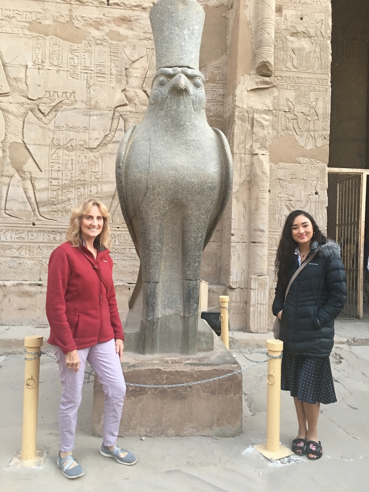 Deux femmes posant devant une sculpture égyptienne antique.