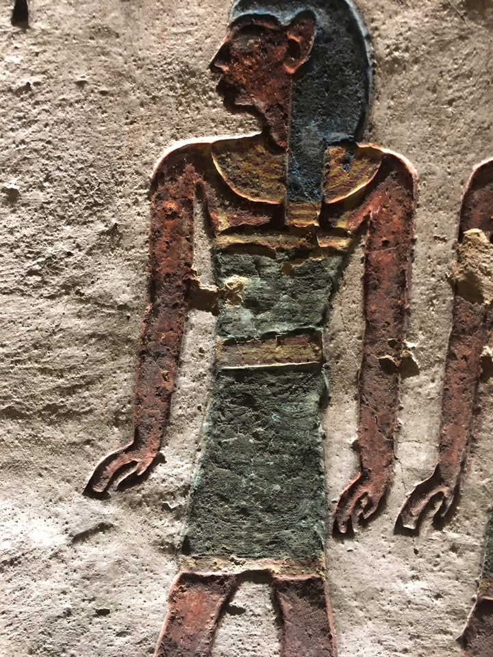 Figure sculptée colorée dans une peinture murale de l'Égypte ancienne.