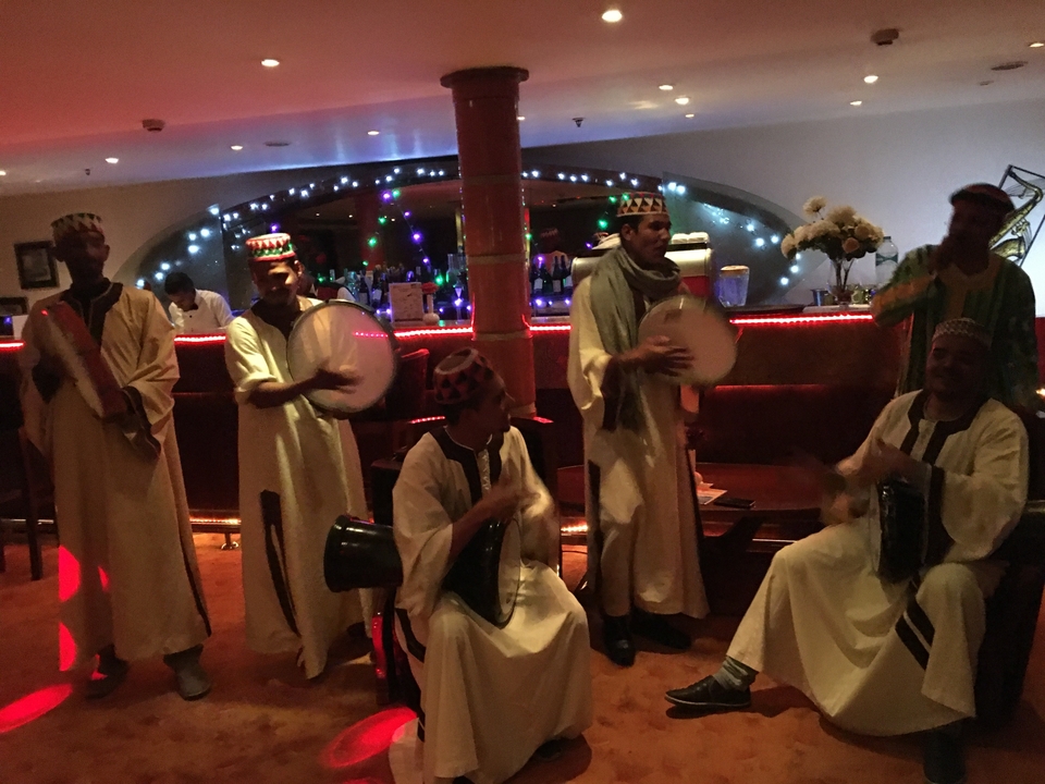 Groupe de musiciens se produisant dans un bar faiblement éclairé.
