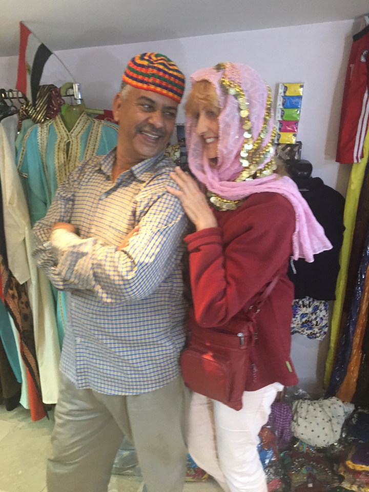 Deux personnes dans un marché, l'une portant une coiffure décorative.