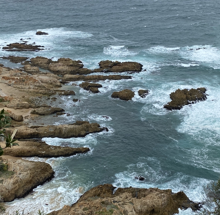 Côte rocheuse avec des vagues qui se brisent.