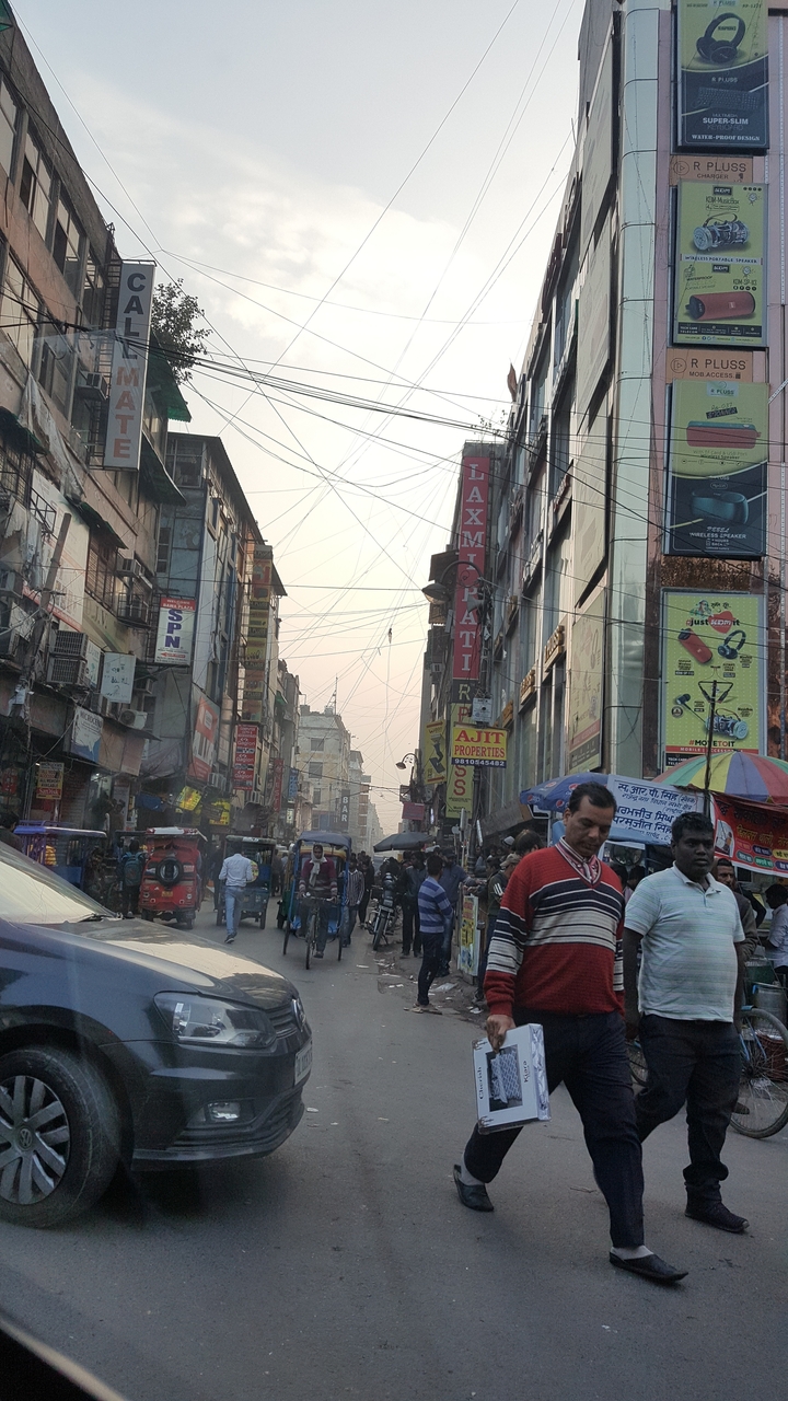 Rue urbaine animée avec de nombreux panneaux et des gens.