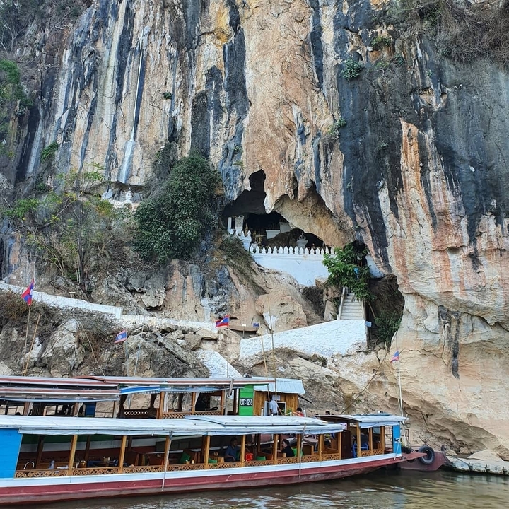 Entrée de grotte avec marches et drapeaux.