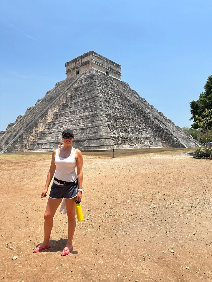 Femme devant une grande pyramide.