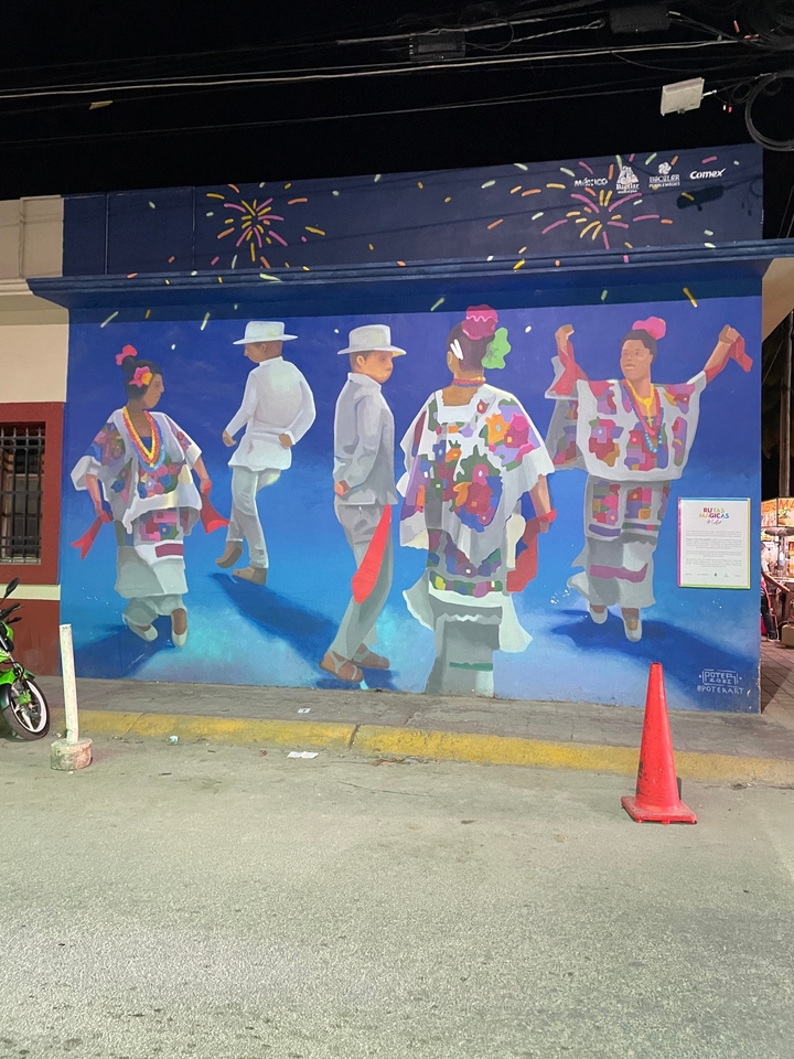 Peinture murale représentant des danseurs traditionnels en costume coloré.