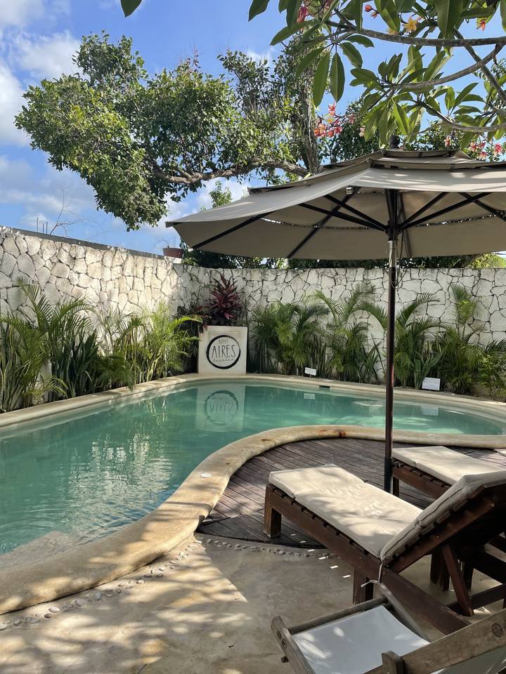 Resort area with swimming pool and sun loungers under umbrellas.