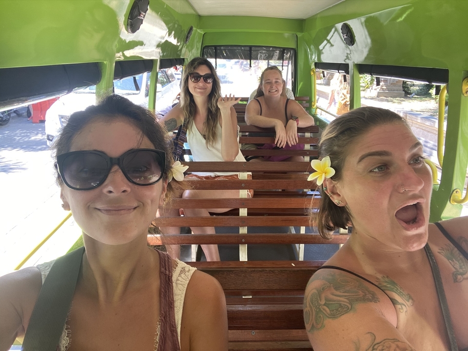 Quatre femmes souriantes en conduisant un petit véhicule ouvert.