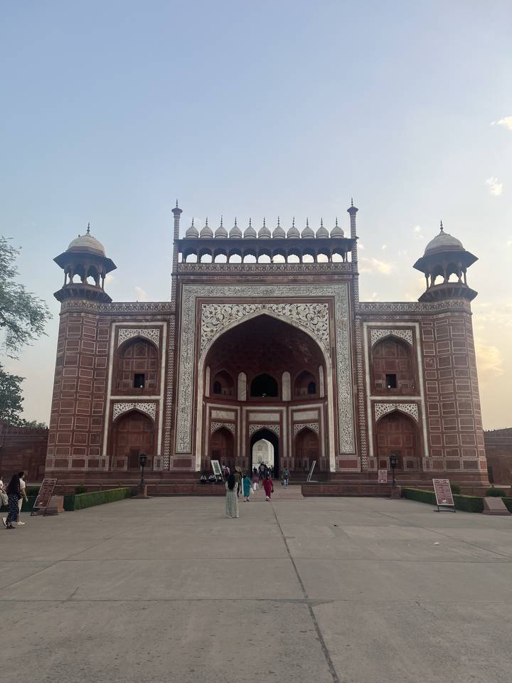 Close-up of a red sandstone gateway with intricate carvings.