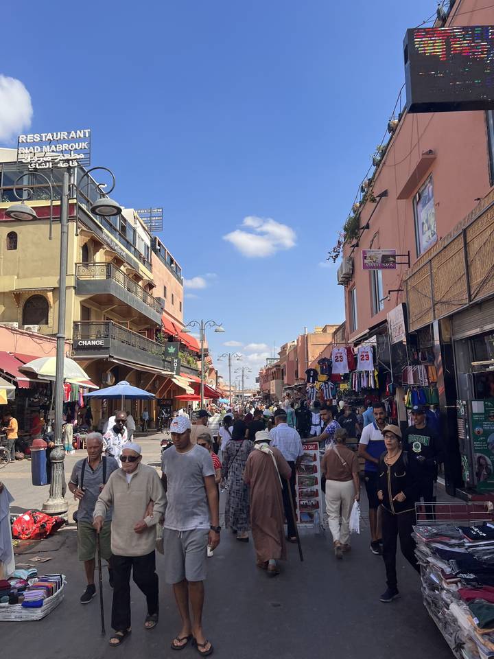 Marché de rue animé avec des gens et des boutiques.